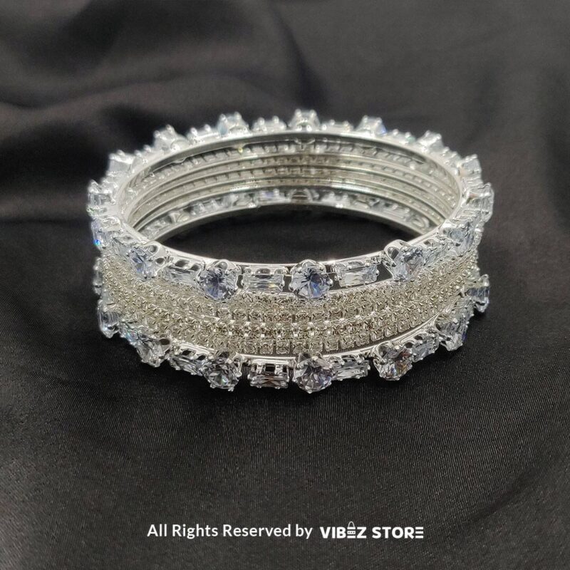 Sparkling Silver-Toned Crystal Bangle Set 1 Silver-toned crystal bangle set with intricate detailing on a black background