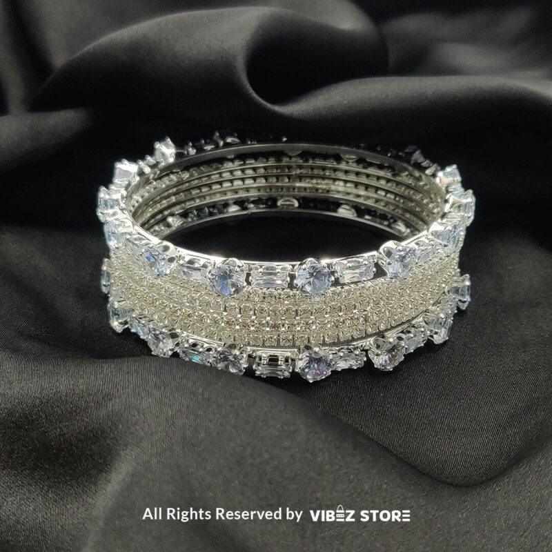 Sparkling Silver-Toned Crystal Bangle Set 3 Silver-toned crystal bangle set with intricate detailing on a black background