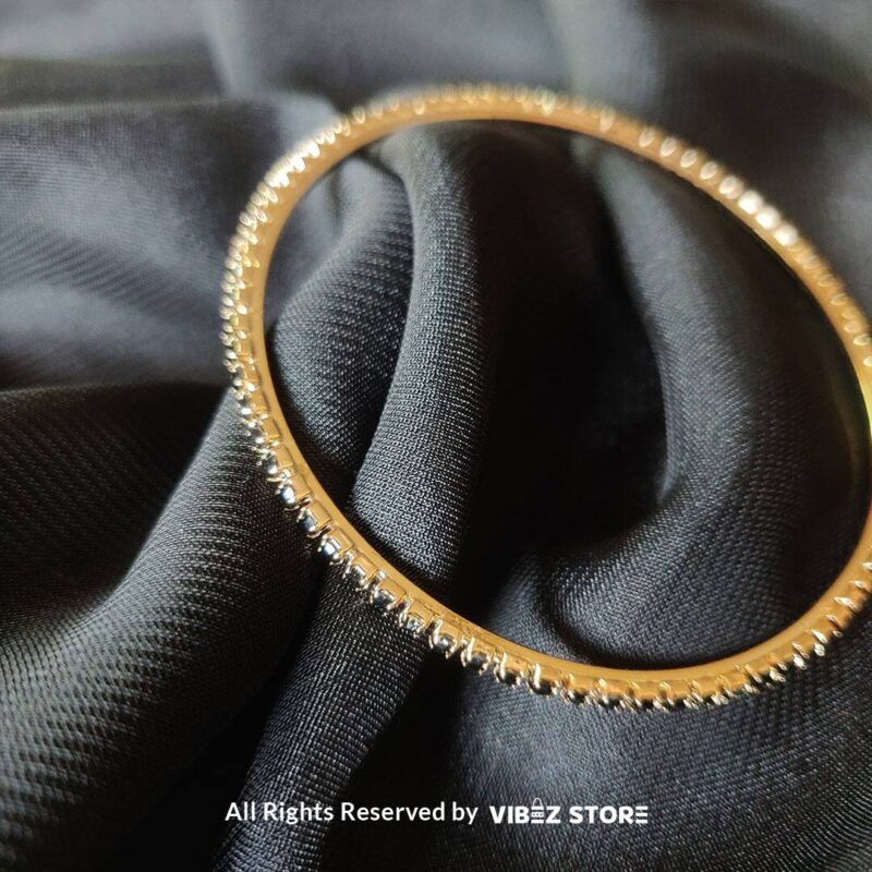 Multi-Layer Black Crystal Gold Bangle Set 3 Multi-layer gold bangle set with black crystal accents on a black fabric background