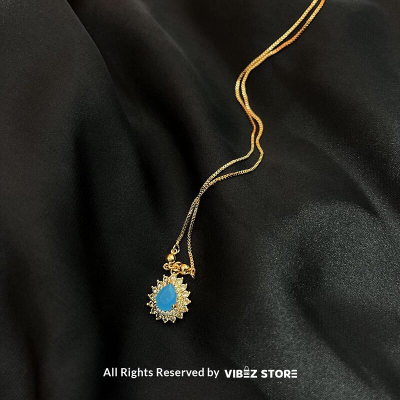 Teardrop Crystal Locket 4 Teardrop Crystal Locket in amber, emerald, and turquoise colors with gold chains on a black background