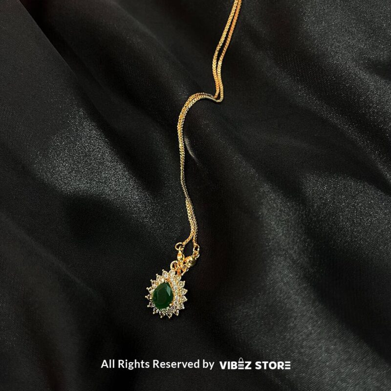 Teardrop Crystal Locket 3 Teardrop Crystal Locket in amber, emerald, and turquoise colors with gold chains on a black background
