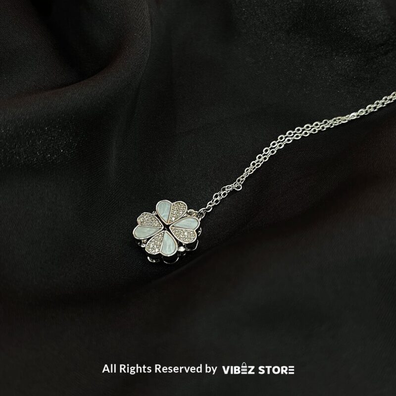 Four-Leaf Clover Locket with Mother-of-Pearl Inlay 1 Four-Leaf Clover Locket with mother-of-pearl inlay and silver-tone chain on a black background