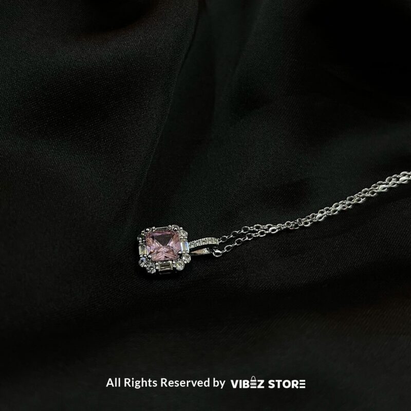 Square Pink Gemstone Locket 1 Square Pink Gemstone Locket with silver-tone chain on a black background
