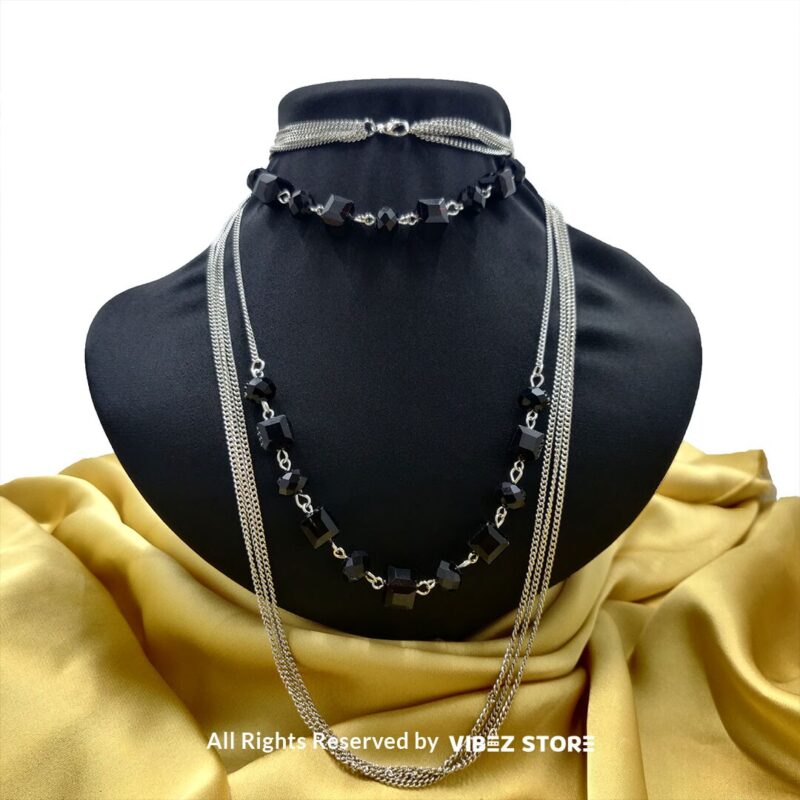 Elegant Crystal Cube and Chain Necklace Set 4 Elegant crystal cube and silver-tone chain necklace set on a black bust with yellow fabric background