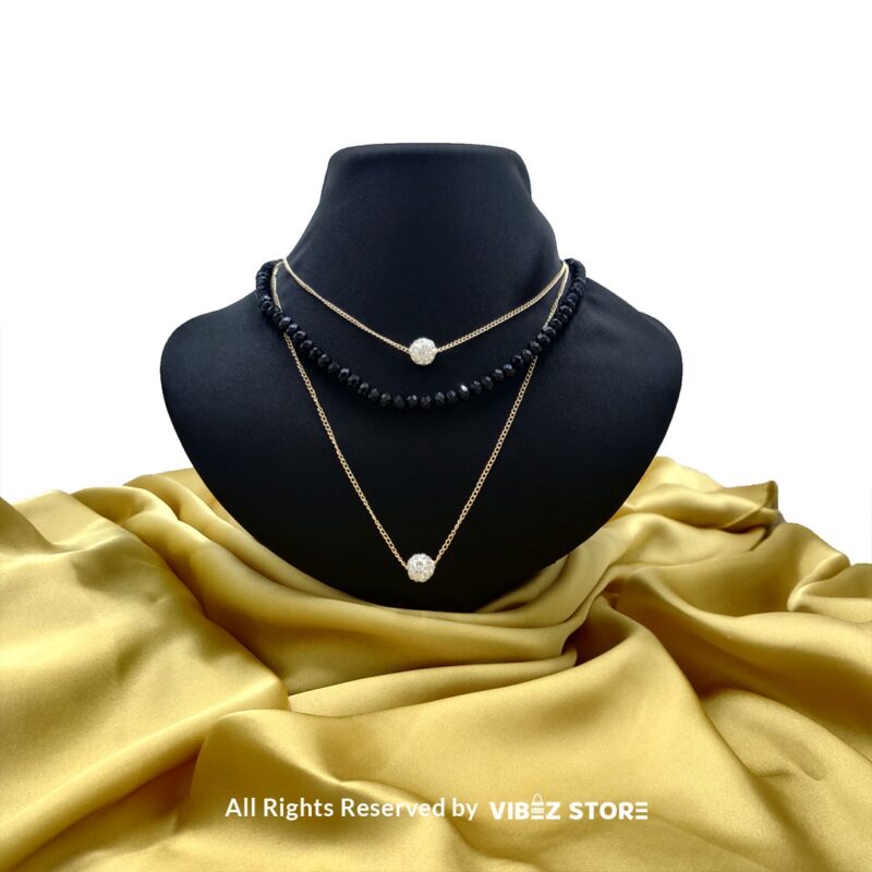 Triple-Layer Beaded and Chain Necklace with Crystal Ball Accent 1 Triple-layer necklace with black beads, gold chains, and crystal ball accent displayed on black bust