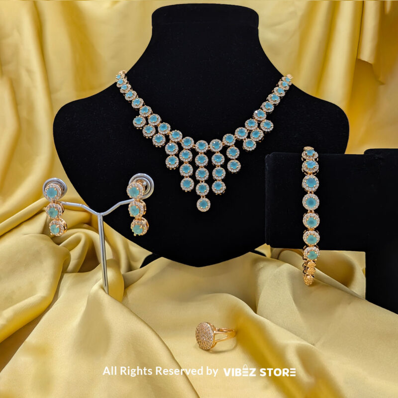 Elegant Aqua Blue Gemstone Jewelry Set 3 Gold-tone jewelry set with aqua blue gemstones, including a necklace, earrings, bracelet, and ring, elegantly displayed by Vibez Store.