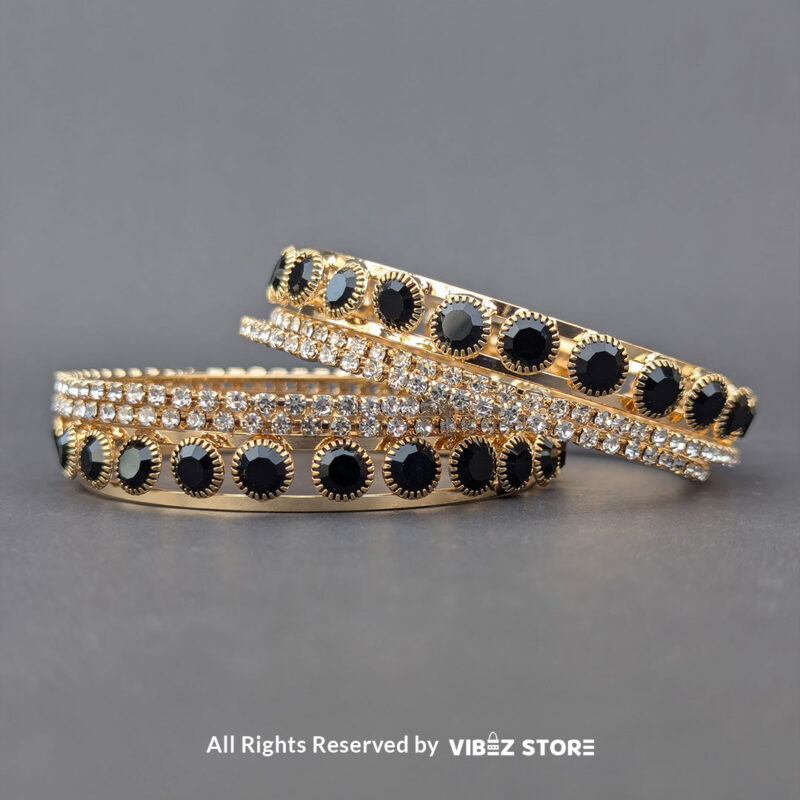Gold-Plated Black Stone and Crystal Bangle Set 1 Gold-plated bangle set with black stones and crystal embellishments on a black background