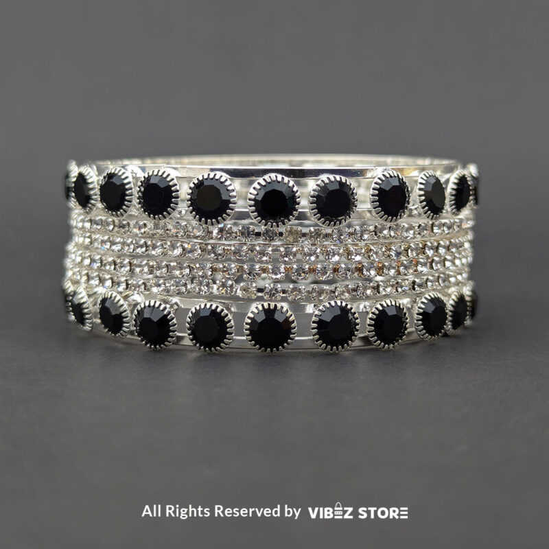 Silver Crystal and Black Stone Bangle Set 3 Silver-tone bangle set with black stones and crystal accents on a black fabric background