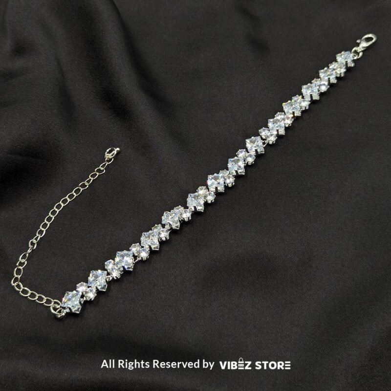 Silver-Tone Crystal Solitaire Bracelet 1 Silver-tone solitaire crystal bracelet with sparkling stones on a black fabric background.