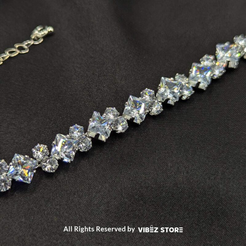 Silver-Tone Crystal Solitaire Bracelet 4 Silver-tone solitaire crystal bracelet with sparkling stones on a black fabric background.