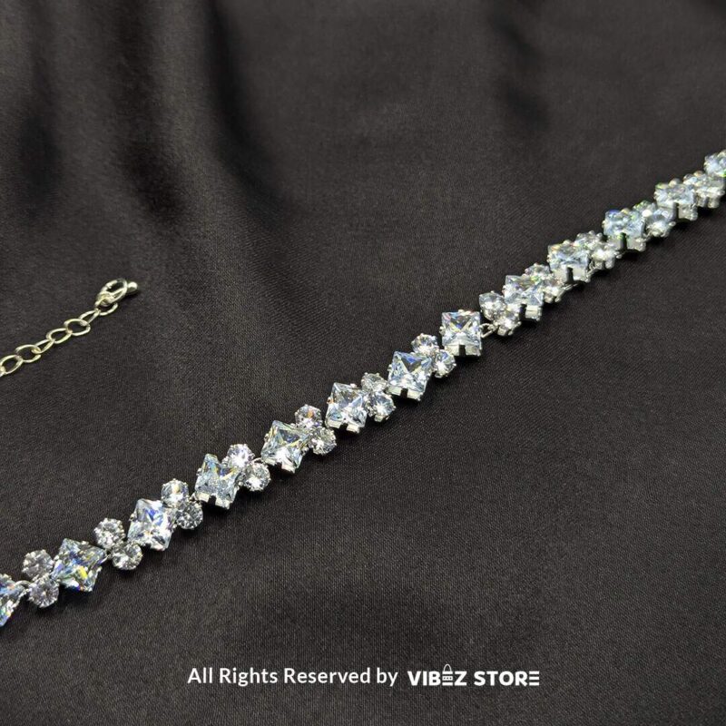 Silver-Tone Crystal Solitaire Bracelet 3 Silver-tone solitaire crystal bracelet with sparkling stones on a black fabric background.