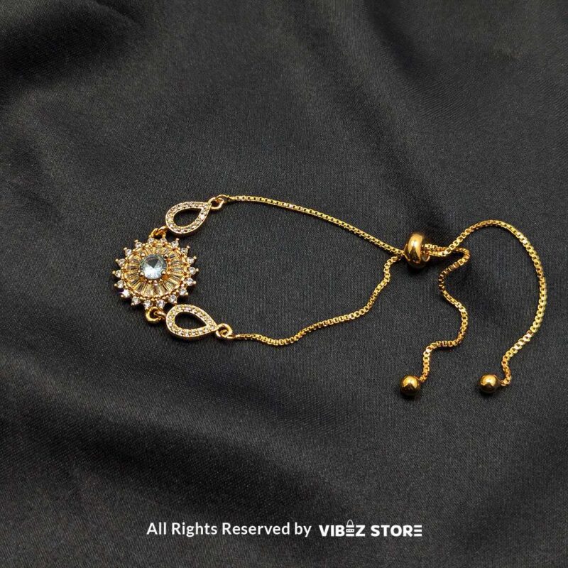Gold-Tone Adjustable Sunburst Crystal Bracelet 3 Gold-tone adjustable bracelet with sunburst crystal centerpiece and teardrop accents on black fabric background