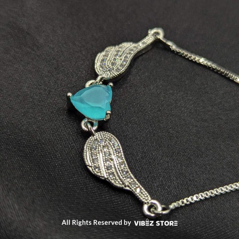 Silver Adjustable Bracelet with Teardrop Turquoise Stone 1 Silver adjustable bracelet with teardrop turquoise stone and intricate detailing on black fabric background