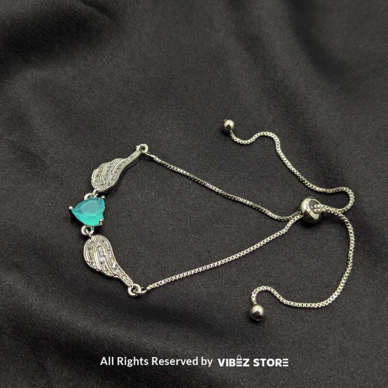 Silver Adjustable Bracelet with Teardrop Turquoise Stone 3 Silver adjustable bracelet with teardrop turquoise stone and intricate detailing on black fabric background