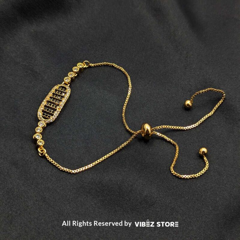 Gold Adjustable Bracelet with Oval Crystal Design 3 Gold adjustable bracelet with oval crystal centerpiece and adjustable chain on black fabric background