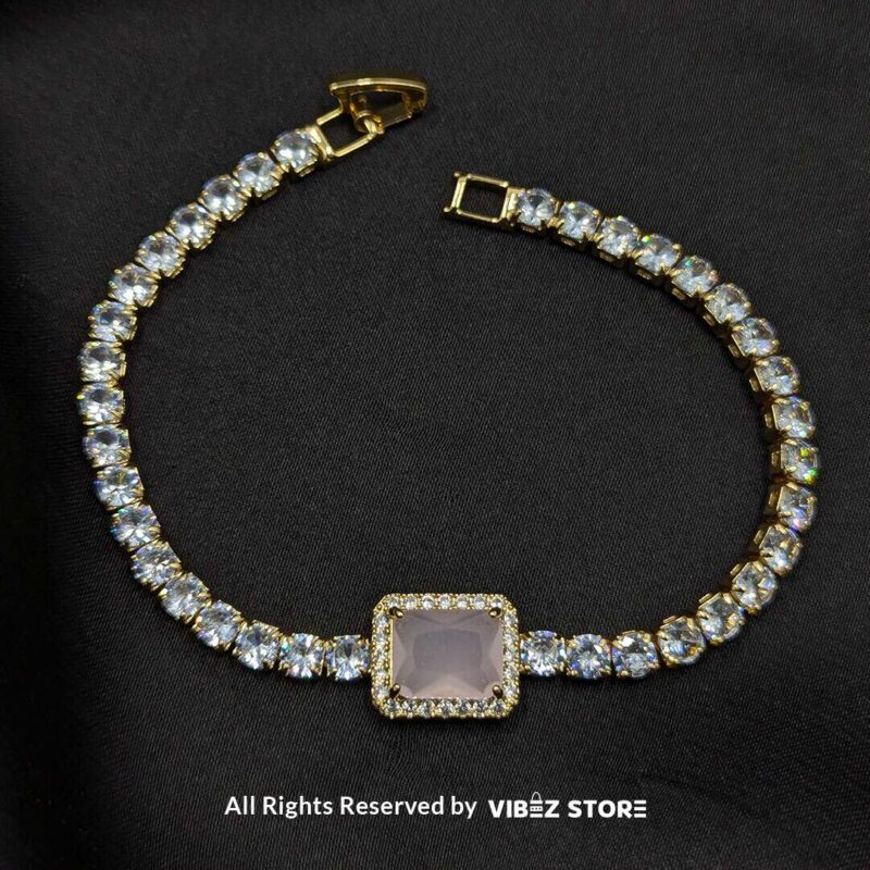 Crystal-Studded Gold Bracelets with Square Gemstone Centerpiece 3 Two crystal-studded gold bracelets with square gemstone centerpieces in ruby red and soft pink on a black fabric background.