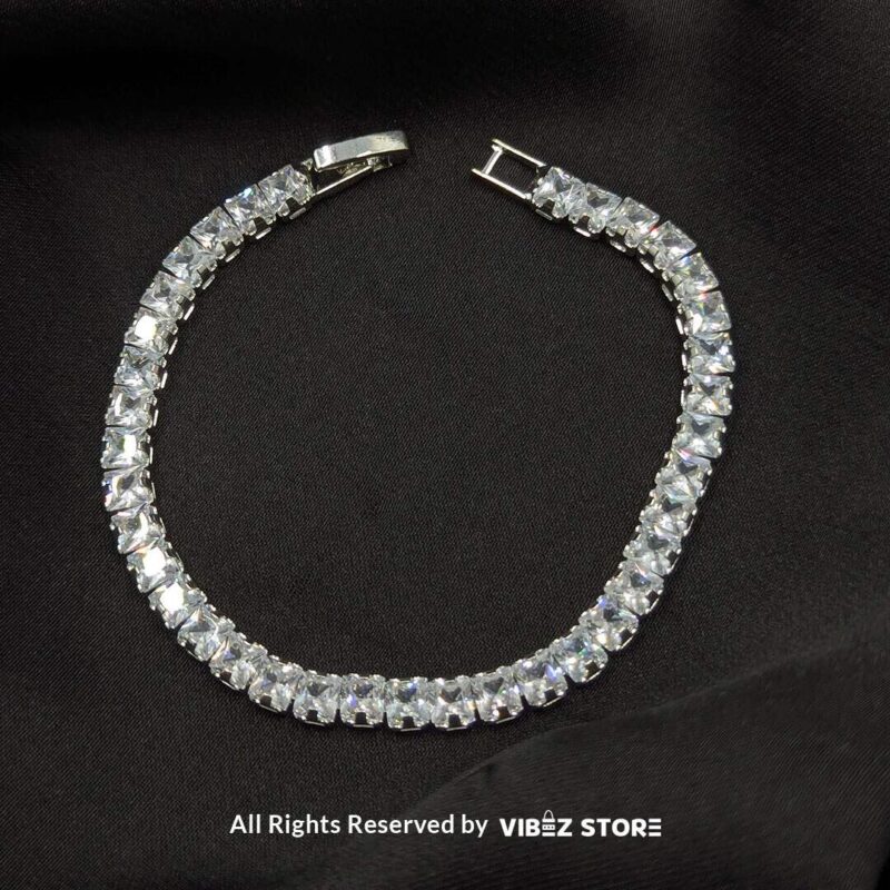 Dual Crystal Tennis Bracelets – Black & White Stones 2 Two crystal tennis bracelets with black and white square-cut stones laid on a black fabric background.