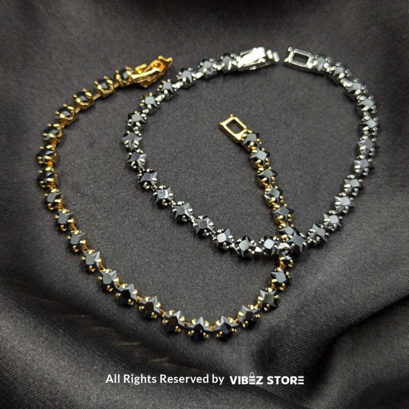 Gold & Silver Starstone Crystal Bracelets – Dual-Tone 1 Two starstone crystal bracelets featuring black stones, one with a gold-tone finish and the other with a silver-tone finish, laid on a black fabric background.