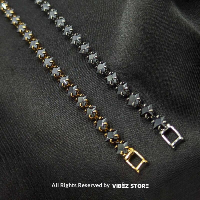 Gold & Silver Starstone Crystal Bracelets – Dual-Tone 6 Two starstone crystal bracelets featuring black stones, one with a gold-tone finish and the other with a silver-tone finish, laid on a black fabric background.