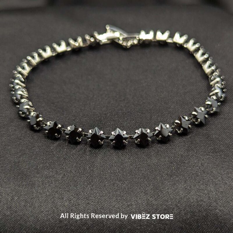 Gold & Silver Starstone Crystal Bracelets – Dual-Tone 3 Two starstone crystal bracelets featuring black stones, one with a gold-tone finish and the other with a silver-tone finish, laid on a black fabric background.