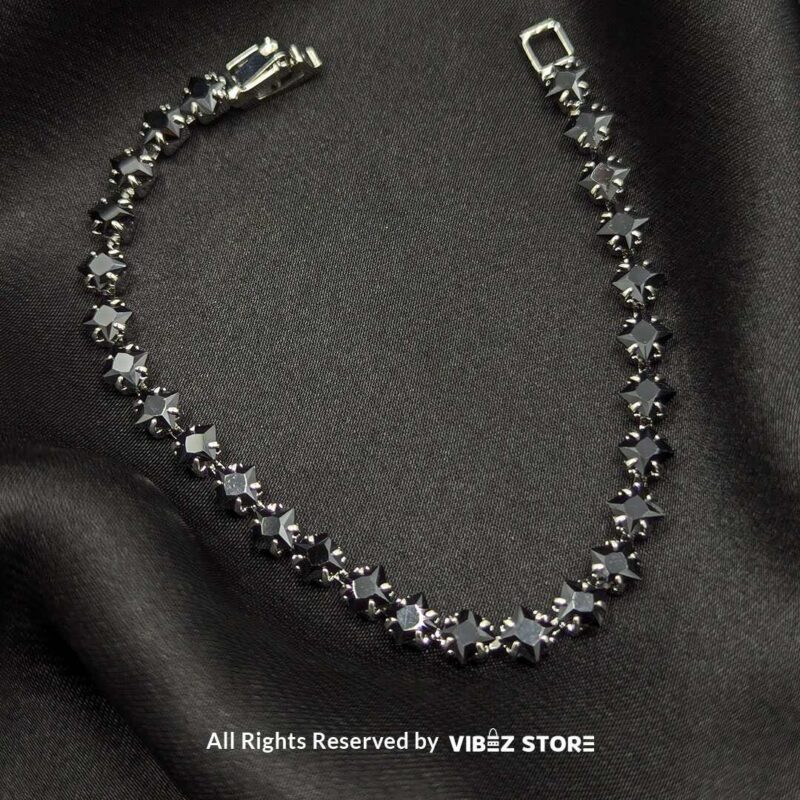 Gold & Silver Starstone Crystal Bracelets – Dual-Tone 2 Two starstone crystal bracelets featuring black stones, one with a gold-tone finish and the other with a silver-tone finish, laid on a black fabric background.