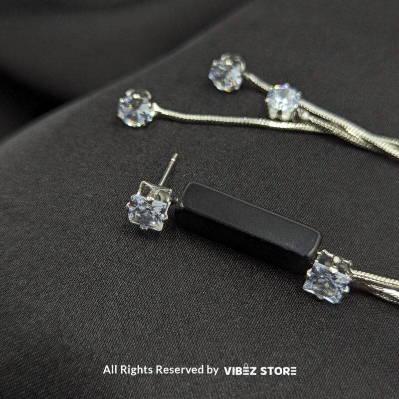 Silver Drape Earrings with Black Accent 3 Stylish silver drape earrings with black accents and sparkling cubic zirconia details displayed on a black satin fabric.
