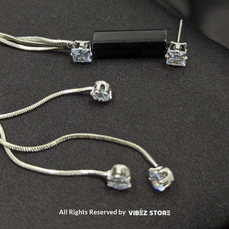 Silver Drape Earrings with Black Accent 2 Stylish silver drape earrings with black accents and sparkling cubic zirconia details displayed on a black satin fabric.
