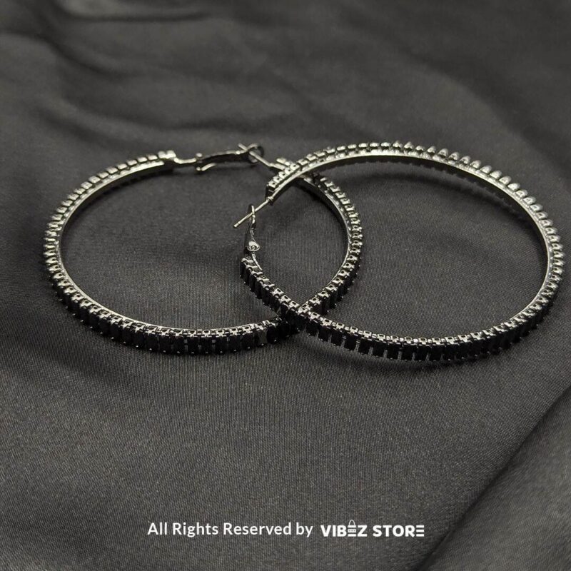 Crystal Hoop Earrings 4 Crystal hoop earrings in gold and black displayed elegantly on a black fabric background.