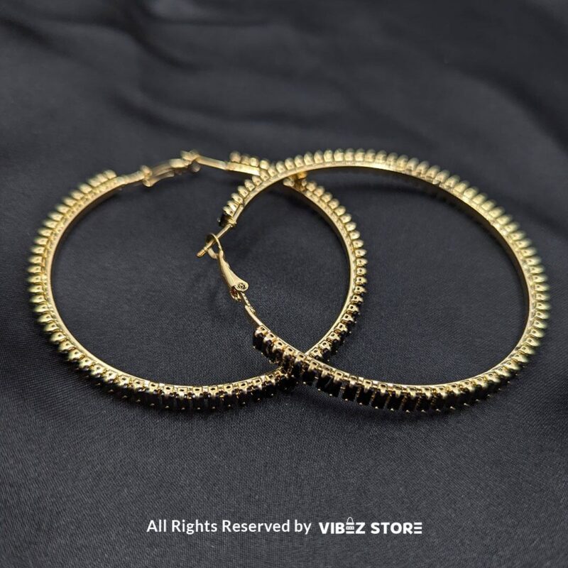 Crystal Hoop Earrings 2 Crystal hoop earrings in gold and black displayed elegantly on a black fabric background.