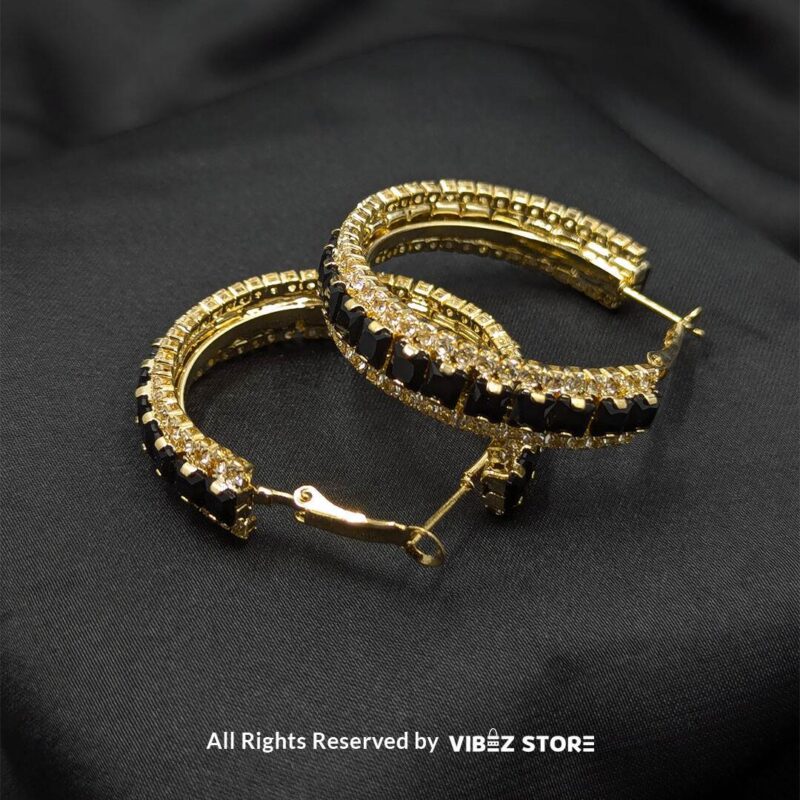Elegant Crystal Hoop Earrings 2 Gold hoop earrings with black crystals and silver hoop earrings with clear crystals displayed against a black fabric background.