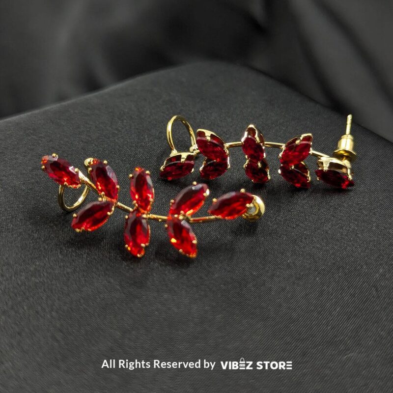 Leaf Design Red Crystal Earrings 3 Golden earrings with vibrant marquise-cut red crystals arranged in a leaf pattern displayed on a black fabric background.