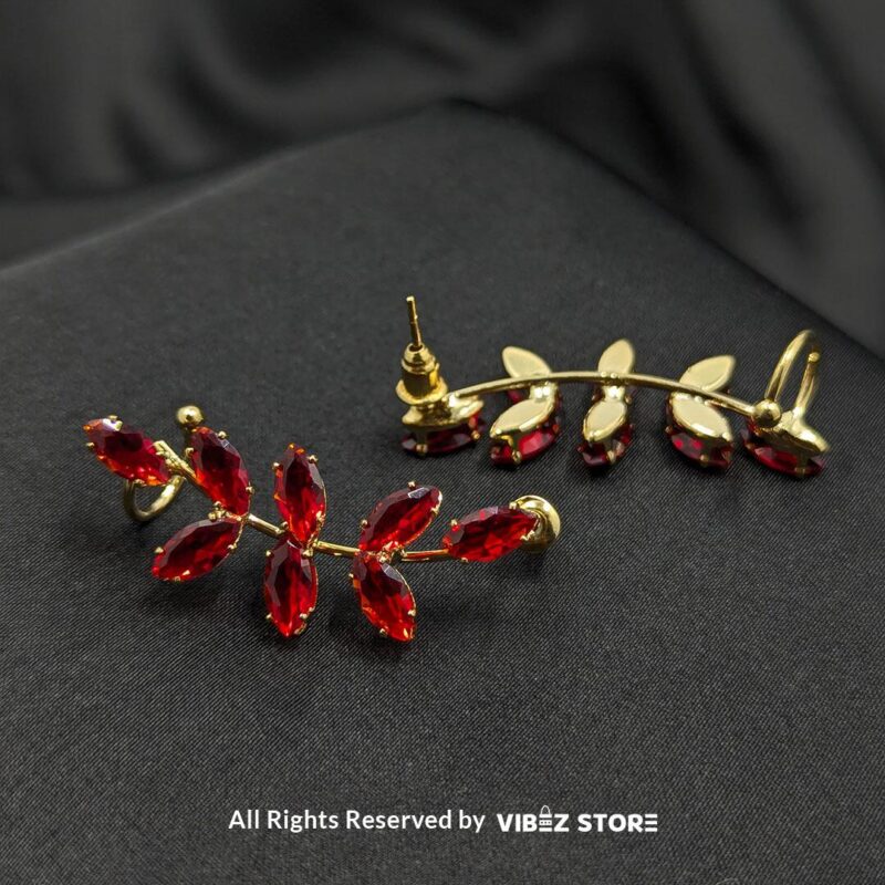 Leaf Design Red Crystal Earrings 2 Golden earrings with vibrant marquise-cut red crystals arranged in a leaf pattern displayed on a black fabric background.