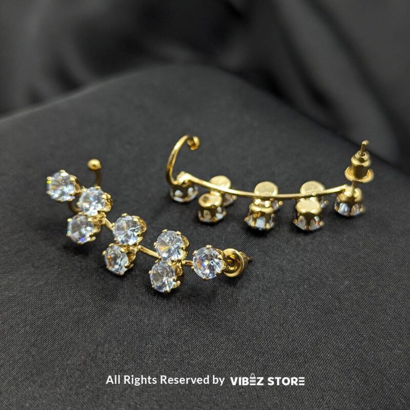 Crystal Cluster Drop Earrings 2 Gold-tone earrings with clusters of round-cut sparkling crystals arranged in a chic drop design, displayed on a black fabric background.