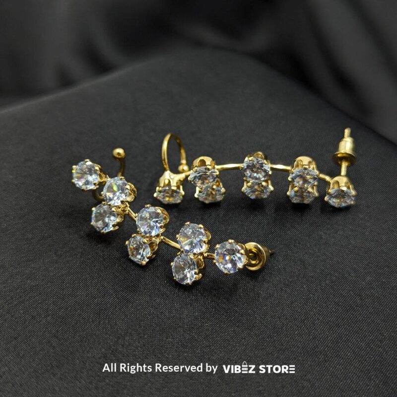 Crystal Cluster Drop Earrings 1 Gold-tone earrings with clusters of round-cut sparkling crystals arranged in a chic drop design, displayed on a black fabric background.