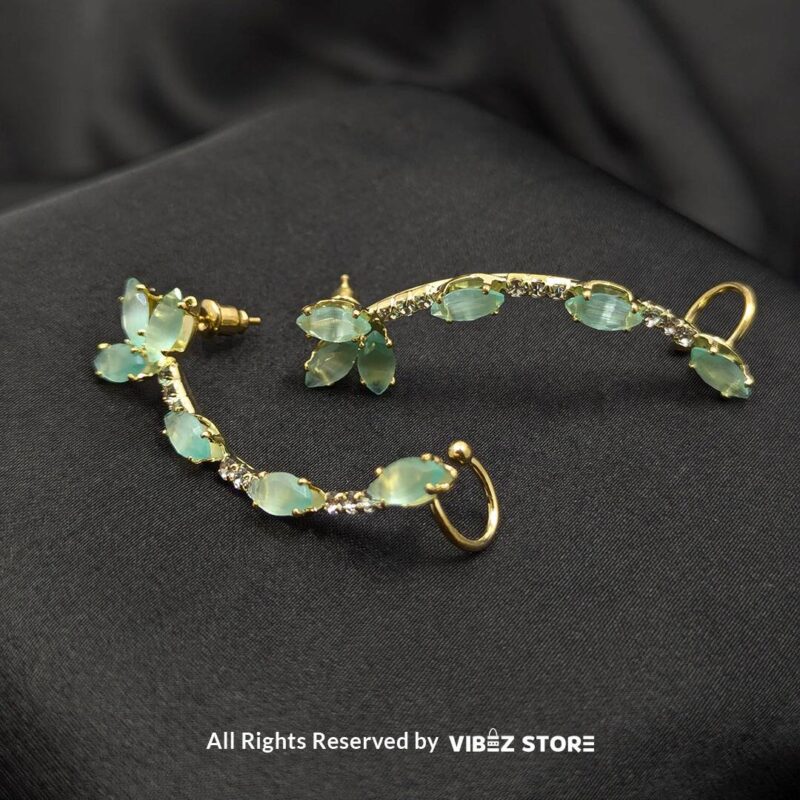 Aqua Curve Drop Earrings 3 Gold-tone earrings featuring aqua stones and crystal accents, designed in a graceful curved shape, displayed on a black fabric background.