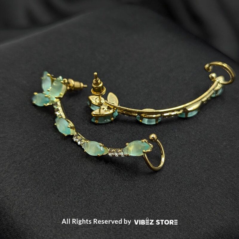 Aqua Curve Drop Earrings 2 Gold-tone earrings featuring aqua stones and crystal accents, designed in a graceful curved shape, displayed on a black fabric background.