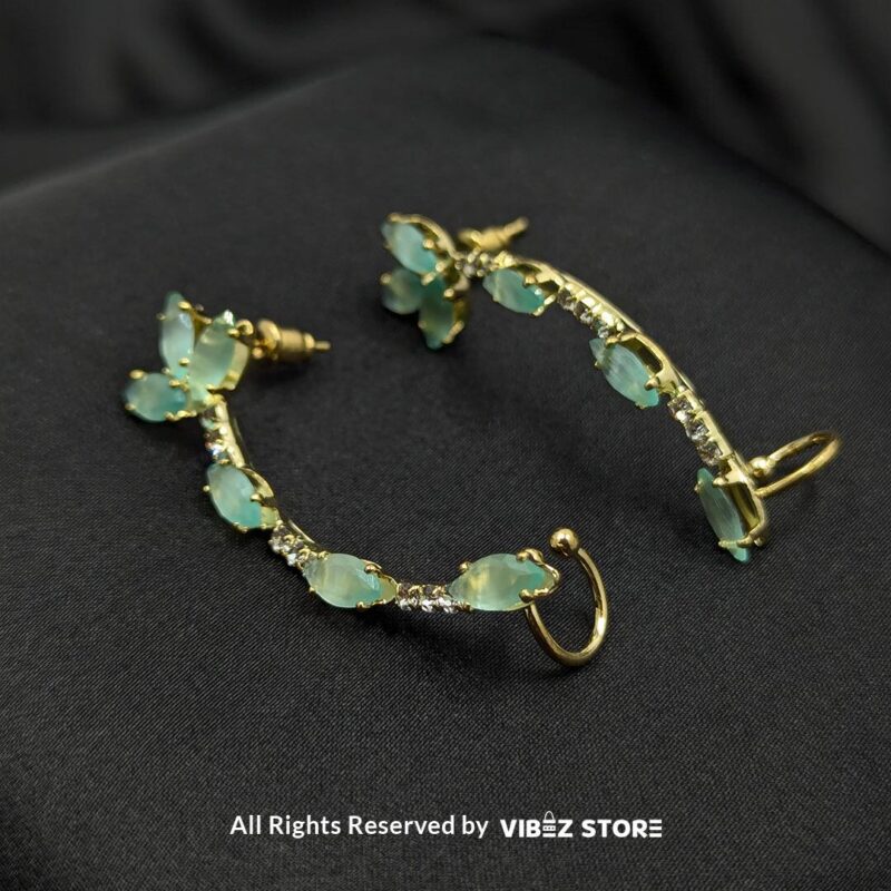 Aqua Curve Drop Earrings 1 Gold-tone earrings featuring aqua stones and crystal accents, designed in a graceful curved shape, displayed on a black fabric background.