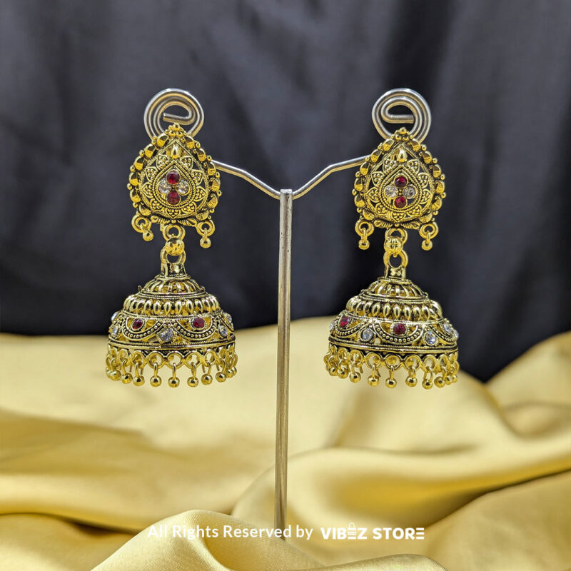 Gold Plated Antique Jhumka Earrings 1 Gold plated antique jhumka earrings with intricate detailing, red stone accents, and bead danglers, perfect for weddings and cultural celebrations.