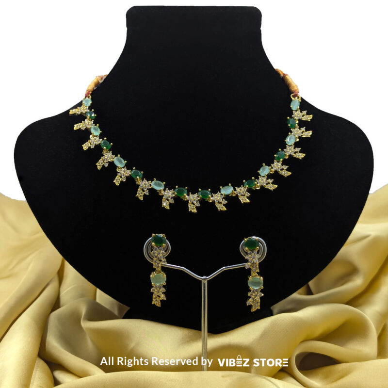 Gold-Plated Green Gemstone Necklace Set with Earrings 1 Gold-plated necklace set with vibrant green gemstones and a matching earring pair displayed on a black mannequin, perfect for weddings and formal events.