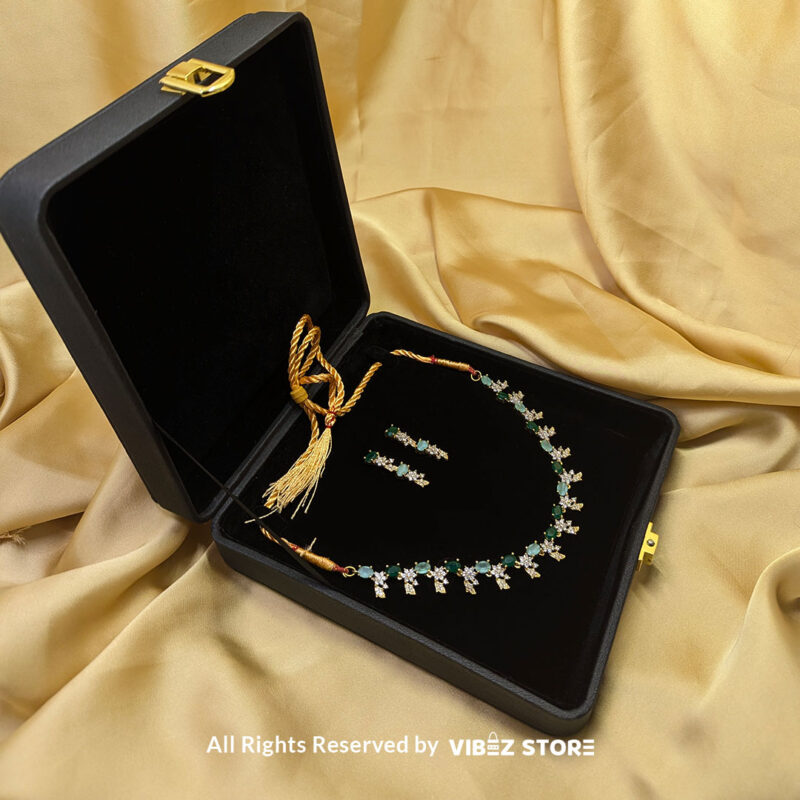 Gold-Plated Green Gemstone Necklace Set with Earrings 3 Gold-plated necklace set with vibrant green gemstones and a matching earring pair displayed on a black mannequin, perfect for weddings and formal events.