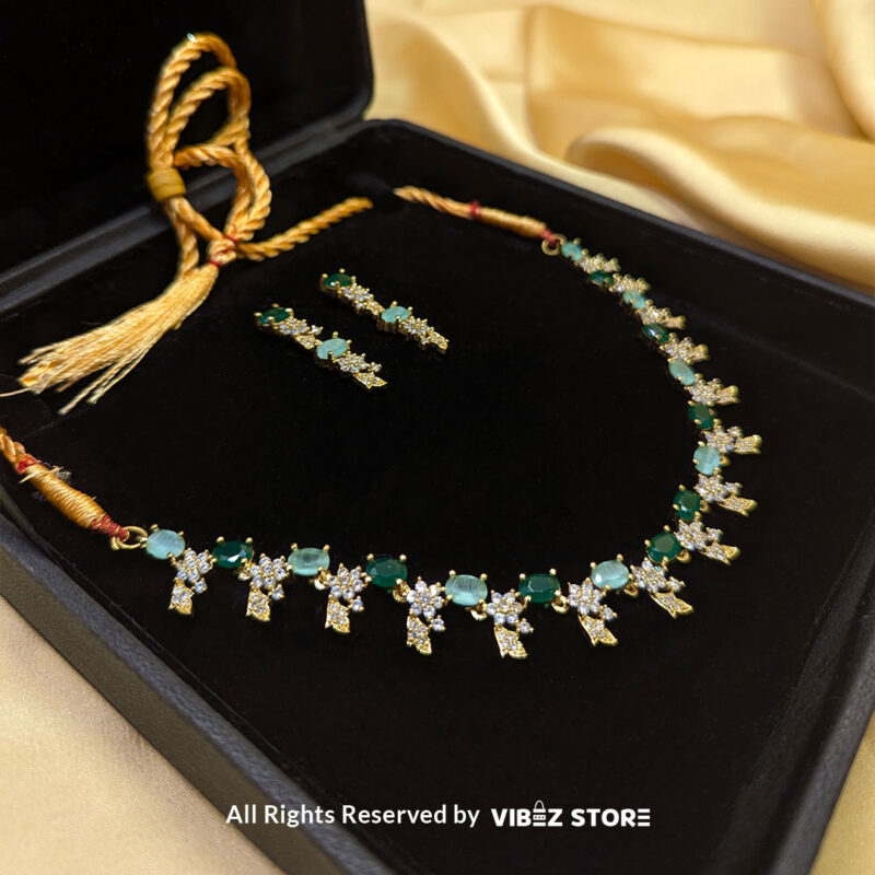 Gold-Plated Green Gemstone Necklace Set with Earrings 2 Gold-plated necklace set with vibrant green gemstones and a matching earring pair displayed on a black mannequin, perfect for weddings and formal events.