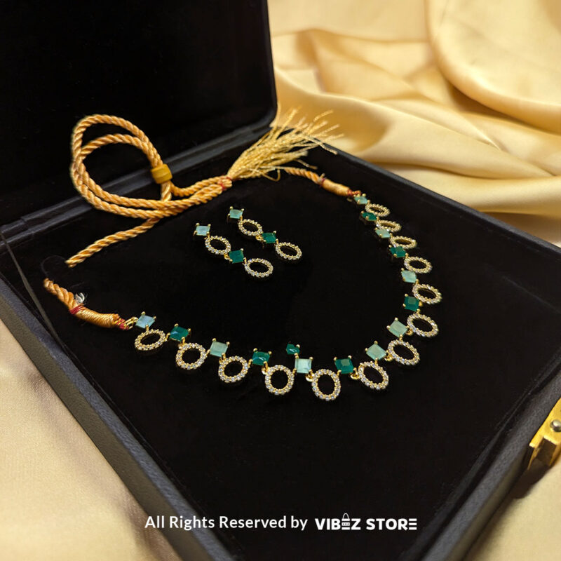 Gold-Plated Oval and Square Green Gemstone Necklace Set with Earrings 2 Gold-plated necklace set featuring oval and square green gemstones with matching drop earrings, elegantly displayed on a black mannequin.
