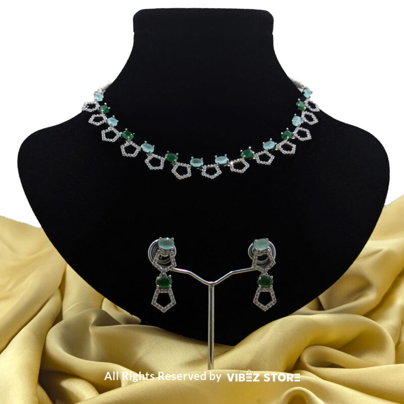 Silver-Plated Green Gemstone Necklace Set with Earrings 1 Silver-plated necklace with green gemstones in a geometric design, paired with matching drop earrings, displayed on a black mannequin.