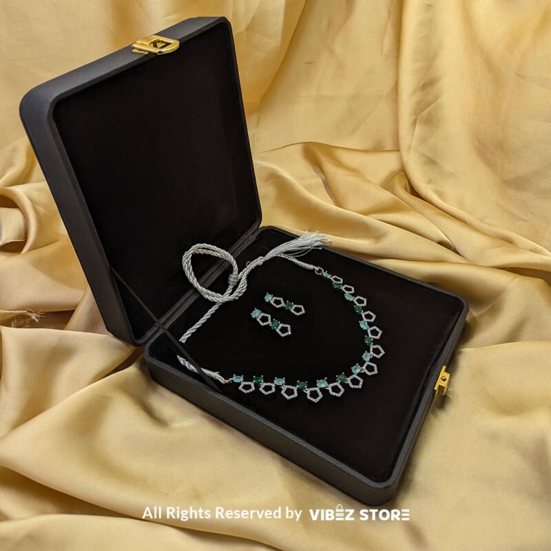 Silver-Plated Green Gemstone Necklace Set with Earrings 3 Silver-plated necklace with green gemstones in a geometric design, paired with matching drop earrings, displayed on a black mannequin.