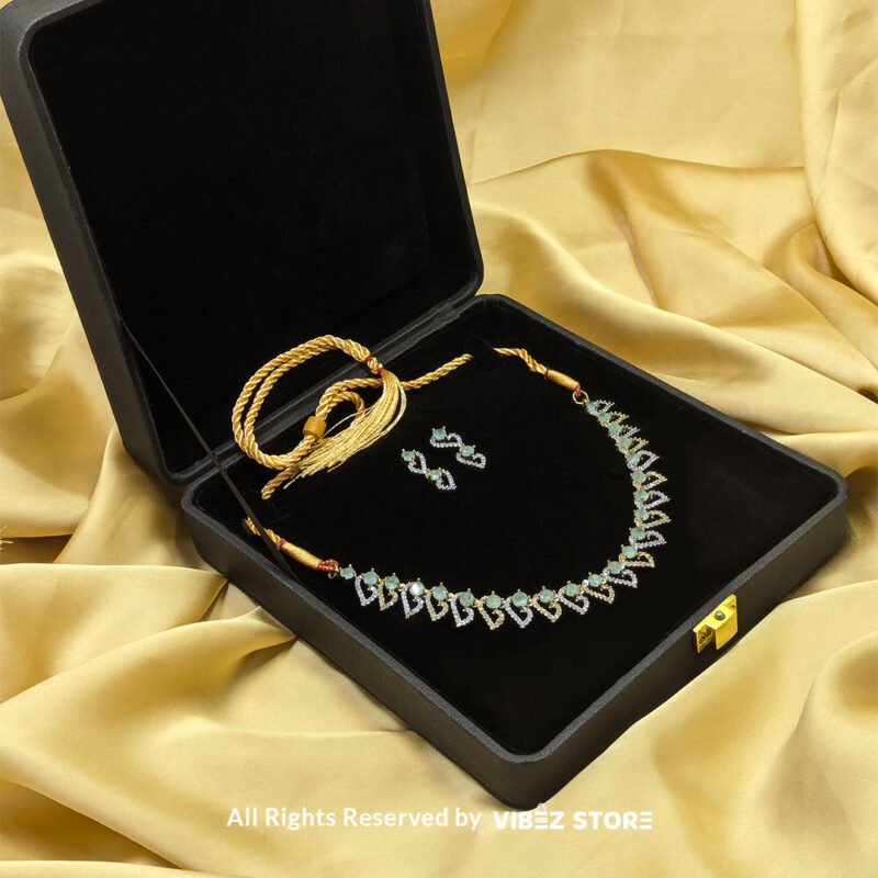 Dual-Tone Green Gemstone Necklace Set with Earrings 3 Dual-tone green gemstone necklace set with matching drop earrings, displayed on a black mannequin with a golden fabric backdrop.
