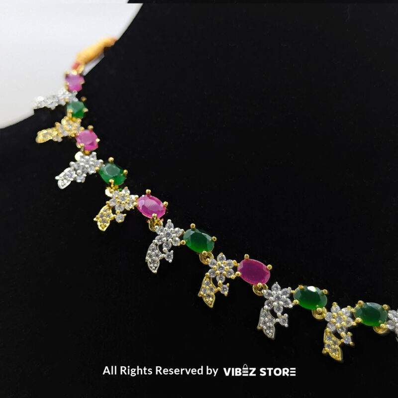 Multicolor Gemstone Necklace Set with Earrings 4 Multicolor gemstone necklace set with green and pink stones, paired with matching earrings, displayed on a black mannequin with a golden fabric backdrop.
