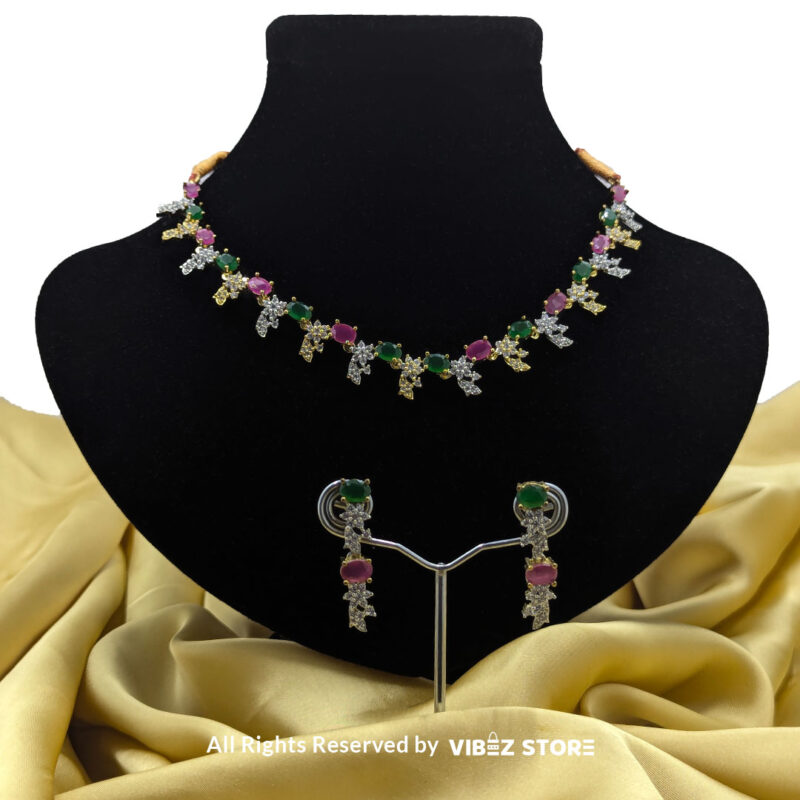 Multicolor Gemstone Necklace Set with Earrings 1 Multicolor gemstone necklace set with green and pink stones, paired with matching earrings, displayed on a black mannequin with a golden fabric backdrop.