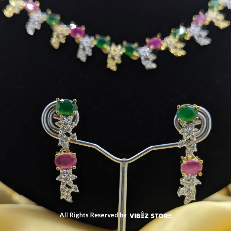 Multicolor Gemstone Necklace Set with Earrings 5 Multicolor gemstone necklace set with green and pink stones, paired with matching earrings, displayed on a black mannequin with a golden fabric backdrop.