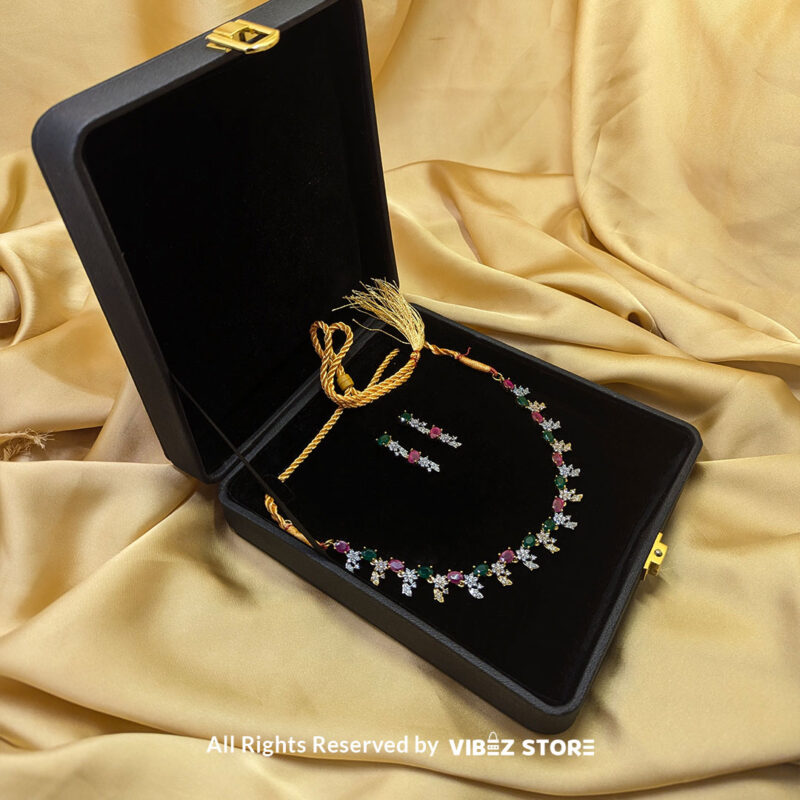 Multicolor Gemstone Necklace Set with Earrings 3 Multicolor gemstone necklace set with green and pink stones, paired with matching earrings, displayed on a black mannequin with a golden fabric backdrop.