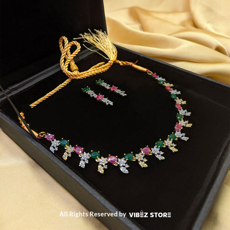 Multicolor Gemstone Necklace Set with Earrings 2 Multicolor gemstone necklace set with green and pink stones, paired with matching earrings, displayed on a black mannequin with a golden fabric backdrop.